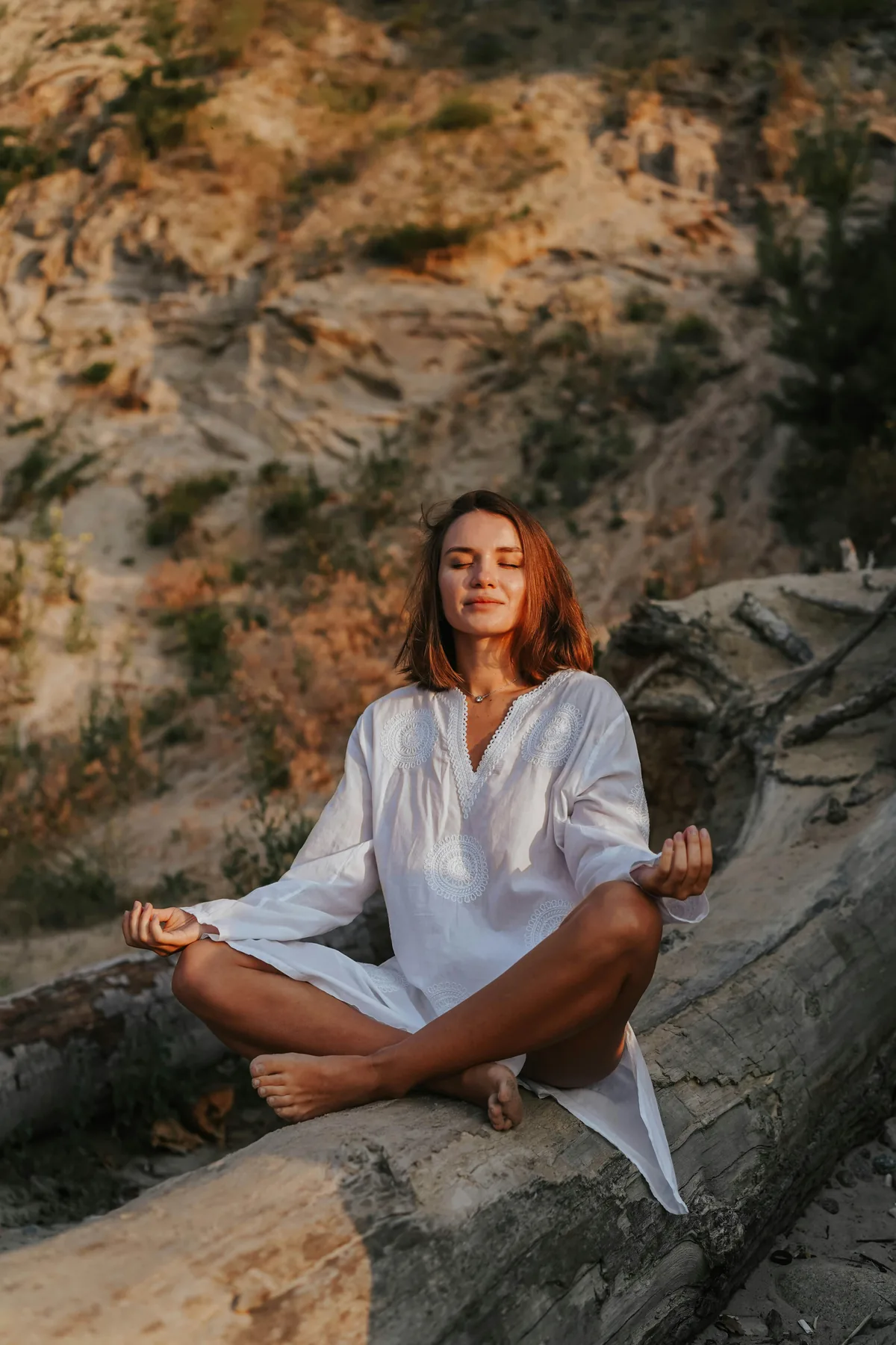 Woman meditating in lotus pose, golden light.