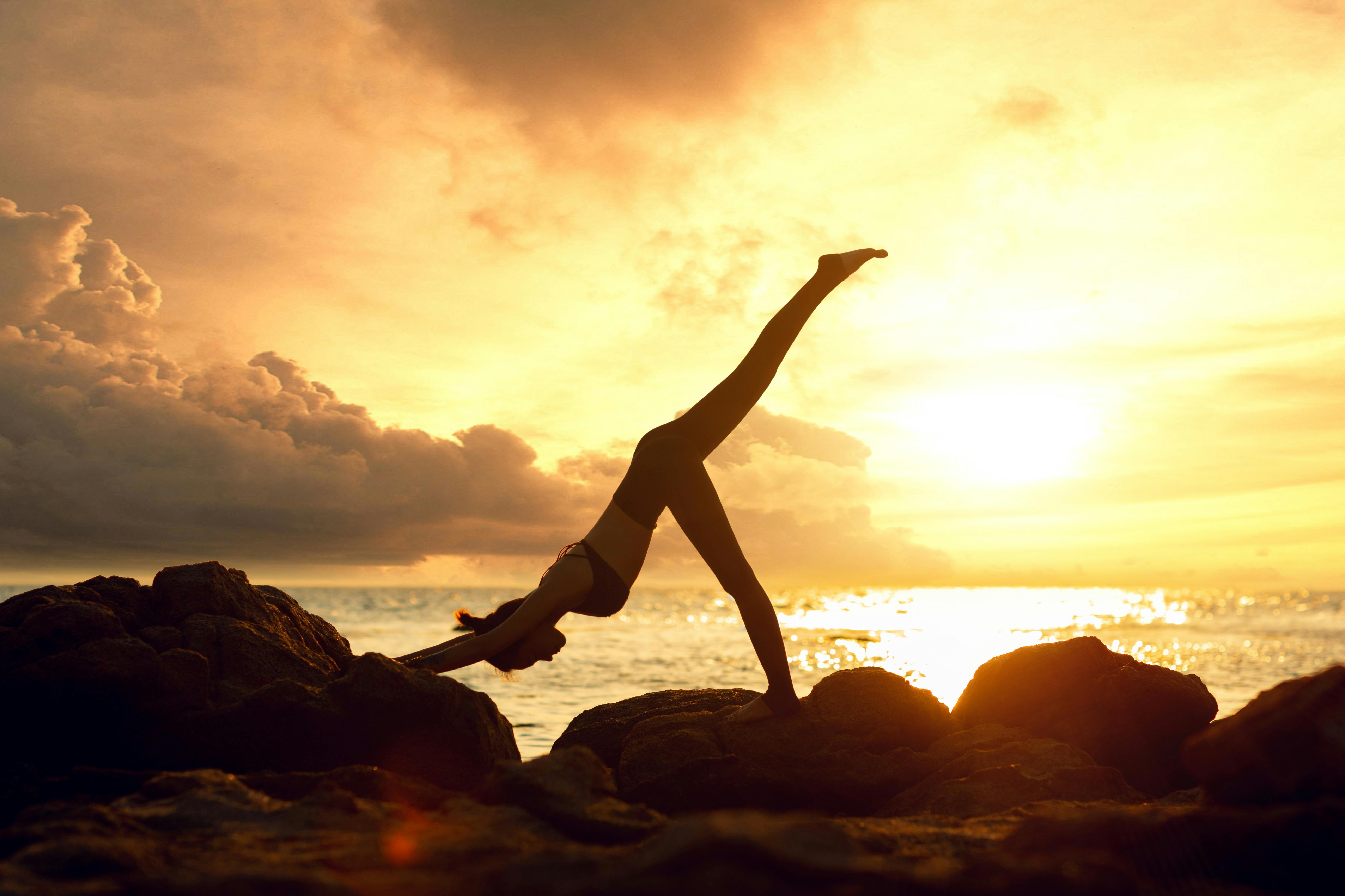 Yoga at golden sunset by the sea in Syros